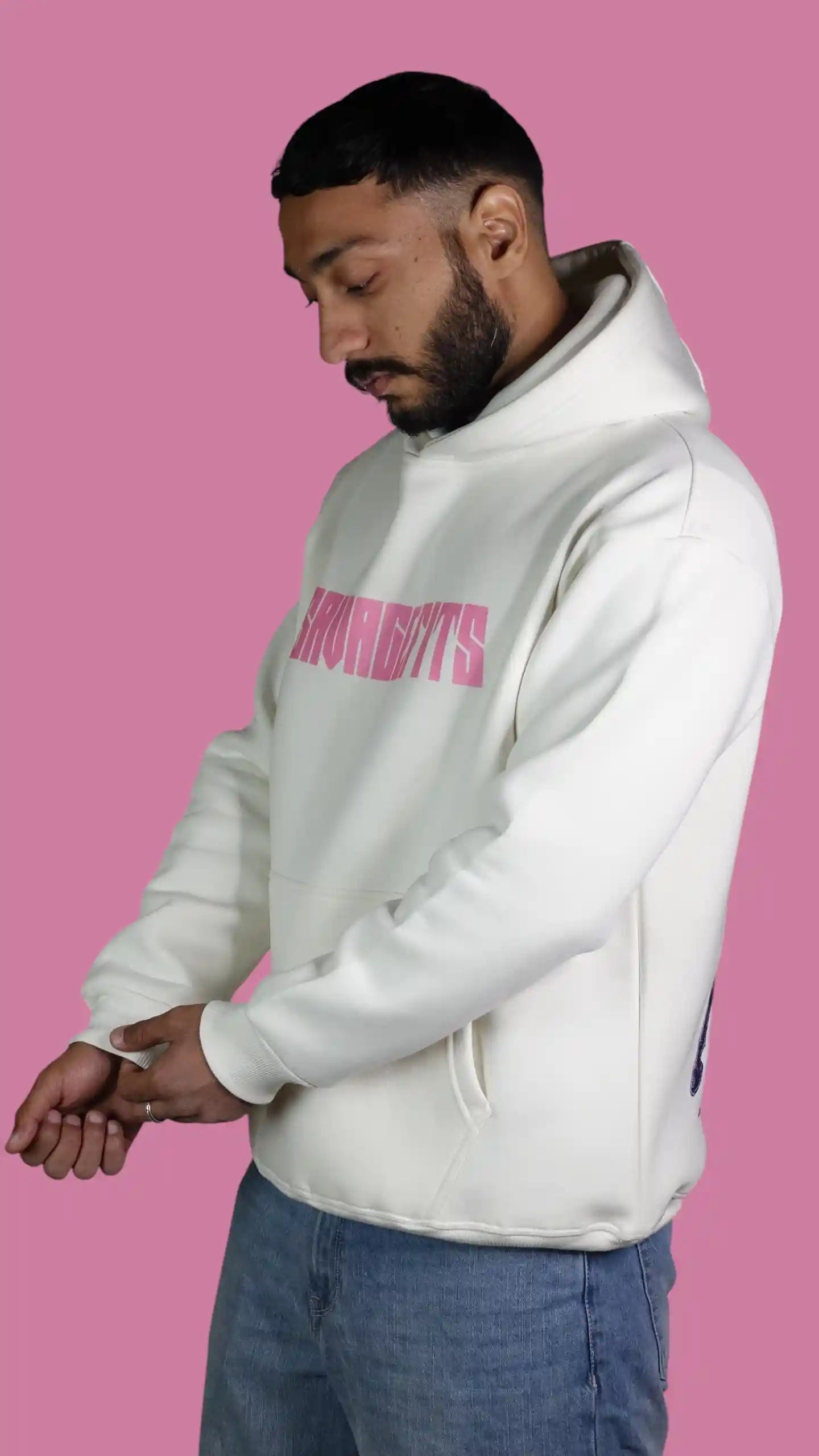 Person wearing a white hoodie with pink text on a pink background