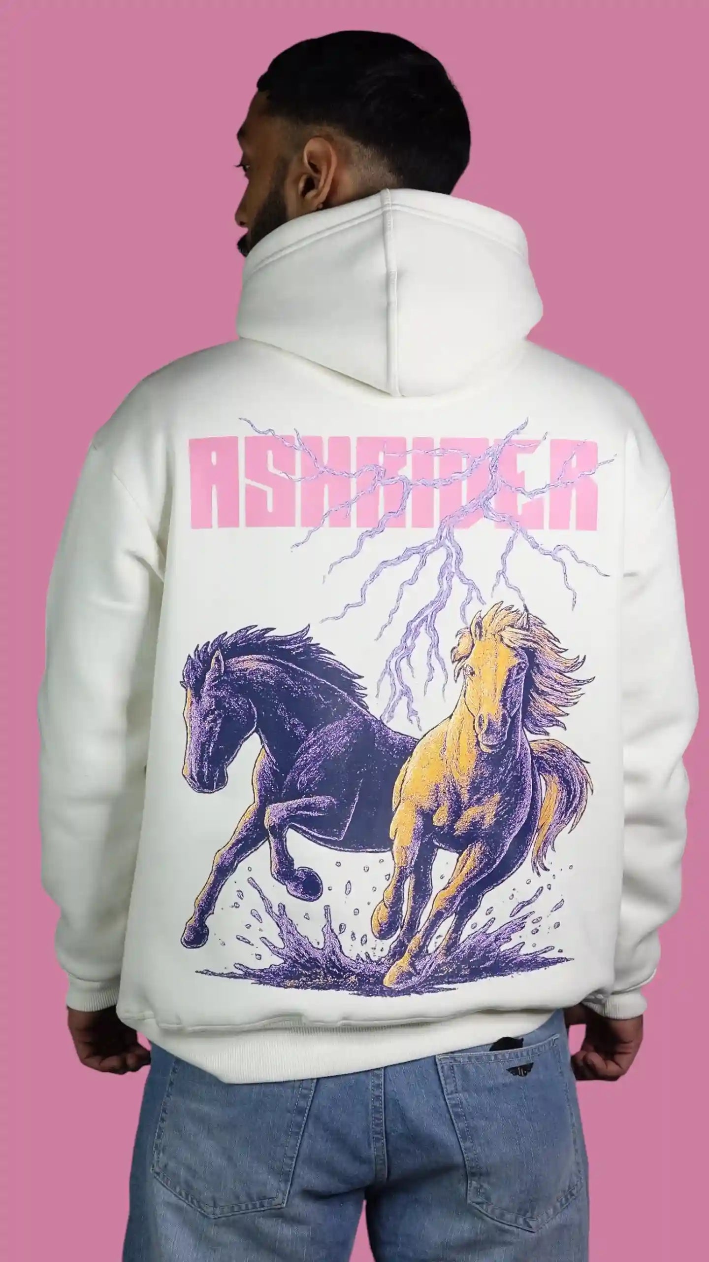 Person wearing a white hoodie with horse design and 'ASHRIDER' text on the back against a pink background