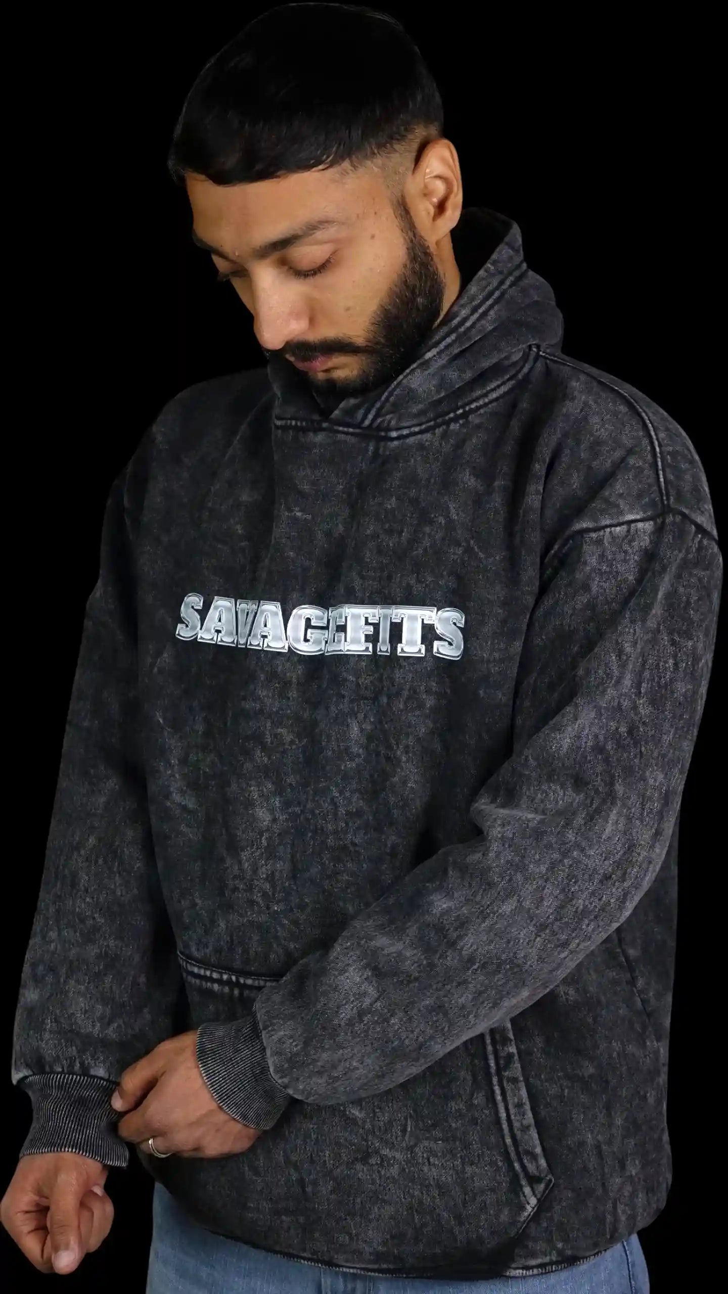 Man wearing a dark gray Acid wash hoodie with 'SAVAGEFITS' text on a black background