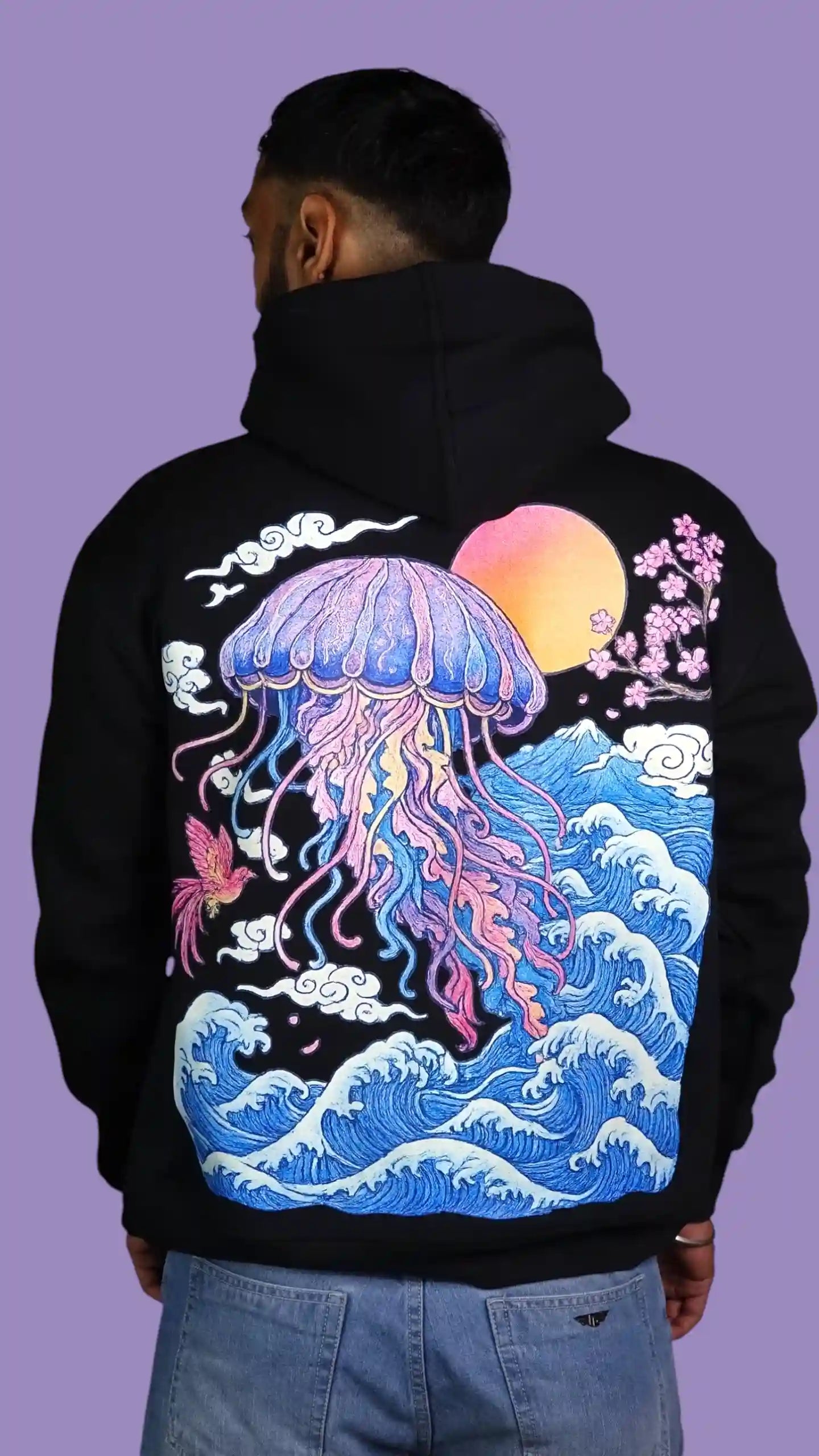 Person wearing a black hoodie with a colorful jellyfish design on the back against a purple background