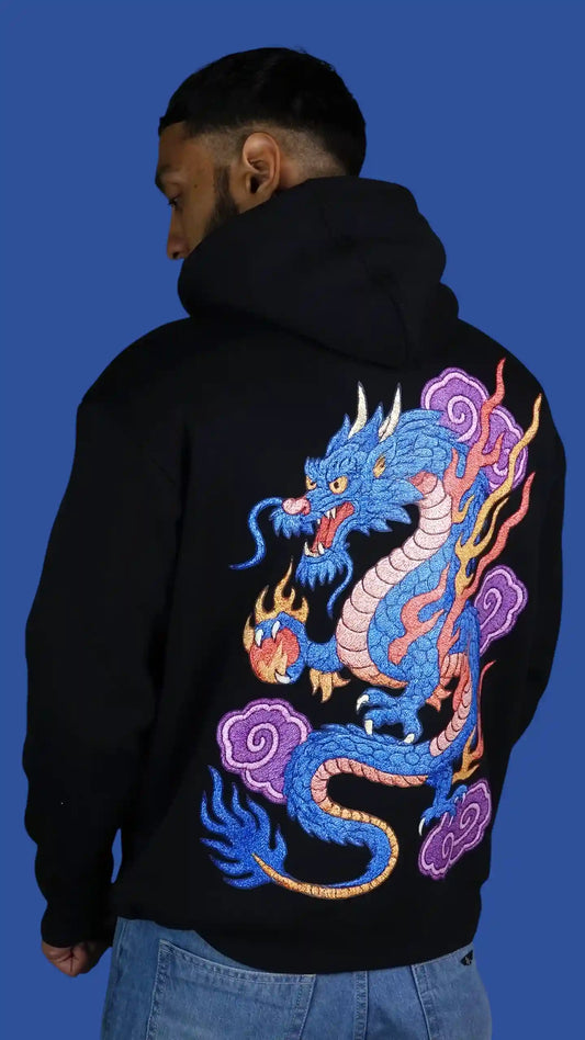 Person wearing a black hoodie with a colorful dragon design on the back against a blue background
